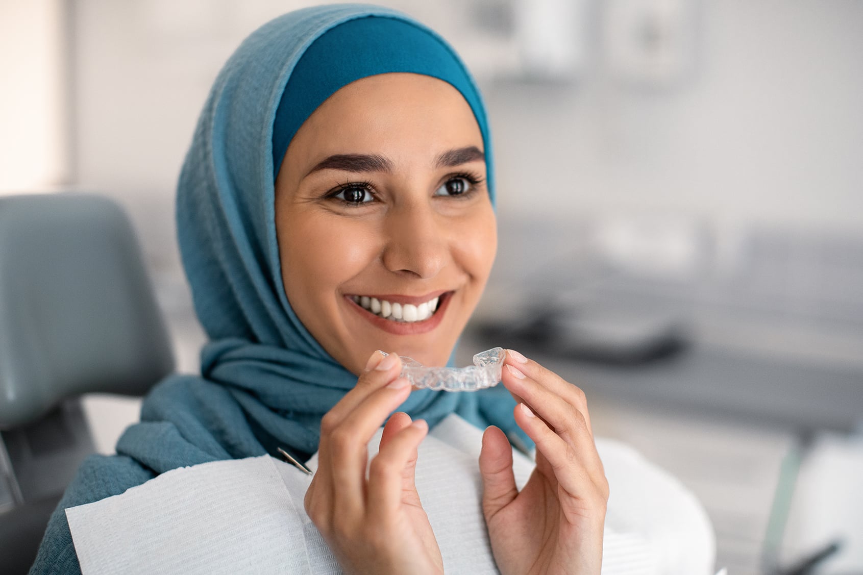 woman placing invisalign at the dentist in noblesville indiana
